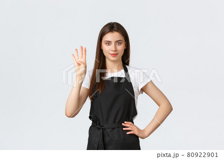 Grocery store employees, small business and coffee shops concept. Cheerful young female barista in black apron showing number four, smiling determined, working in cafe Grocery store employees, small business and coffee shops concept. Cheerful young female barista in black apron showing number four, smiling determined, working in cafe 80922901