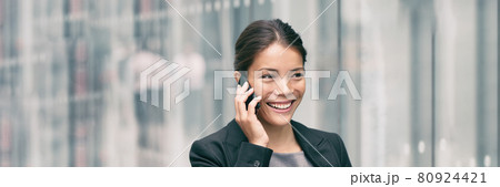Business Asian businesswoman busy talking on smartphone calling while walking to work office commute on city street panoramic banner. Lady at airport or metro Business Asian businesswoman busy talking on smartphone calling while walking to work office commute on city street panoramic banner. Lady at airport or metro 80924421