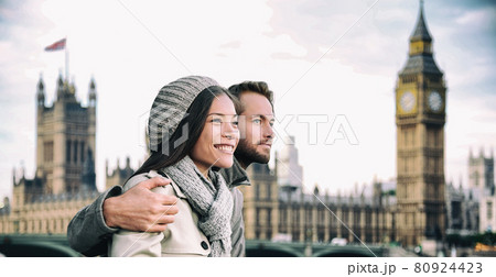Happy couple by Big Ben Parliament, River Thames, London. Romantic young couple enjoying view during travel. Asian woman, Caucasian man in London, England, United Kingdom Happy couple by Big Ben Parliament, River Thames, London. Romantic young couple enjoying view during travel. Asian woman, Caucasian man in London, England, United Kingdom 80924423