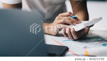 Close up hand of accounting man working on workplace desk in office use calculator calculates monthly expenses, taxes, check bank account balance 80924700