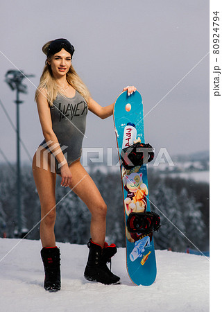 Attractive woman dressed in swimsuit with snowboard on the slope Attractive woman dressed in swimsuit with snowboard on the slope 80924794