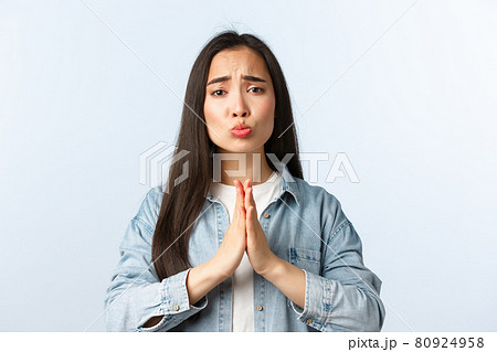 Lifestyle, people emotions and beauty concept. Silly and cute pleading asian girl begging for favour or apology, grimacing looking sad eyes, hold hands in pray as need help, white background Lifestyle, people emotions and beauty concept. Silly and cute pleading asian girl begging for favour or apology, grimacing looking sad eyes, hold hands in pray as need help, white background 80924958