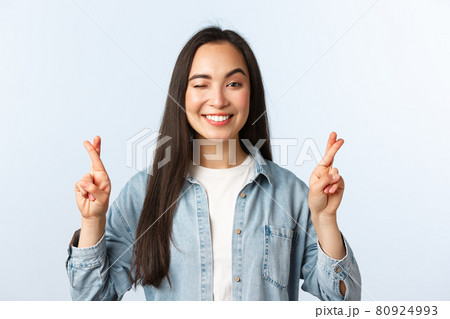 Lifestyle, people emotions and beauty concept. Hopeful optimistic pretty asian girl making wish. Female student fingers crossed before test results, wink and smiling, praying receive good news Lifestyle, people emotions and beauty concept. Hopeful optimistic pretty asian girl making wish. Female student fingers crossed before test results, wink and smiling, praying receive good news 80924993