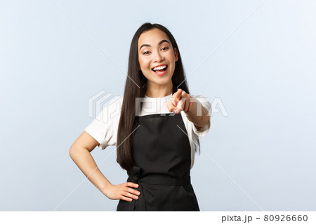 Coffee shop, small business and startup concept. Cheerful friendly asian barista or restaurant employee, smiling and pointing finger at camera, inviting come to cafe, white background 80926660