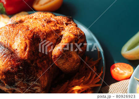 Freshly grilled chicken on blue plate with potatoes and tomatoes on blue background Freshly grilled chicken on blue plate with potatoes and tomatoes on blue background 80926923