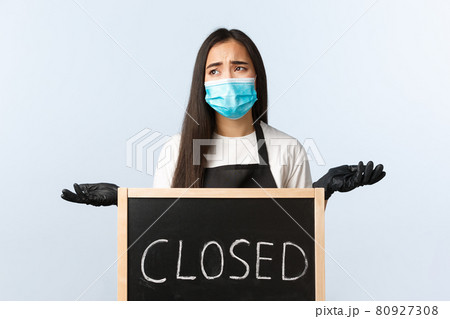 Small business, covid-19 pandemic, preventing virus and employees concept. Uneasy and distressed cafe employee or owner complaining on coronavirus lockdown, cant work, shrugging near closed sign Small business, covid-19 pandemic, preventing virus and employees concept. Uneasy and distressed cafe employee or owner complaining on coronavirus lockdown, cant work, shrugging near closed sign 80927308
