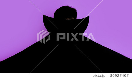 Man in dracula costume stands with his back in black cloak Man in dracula costume stands with his back in black cloak 80927407