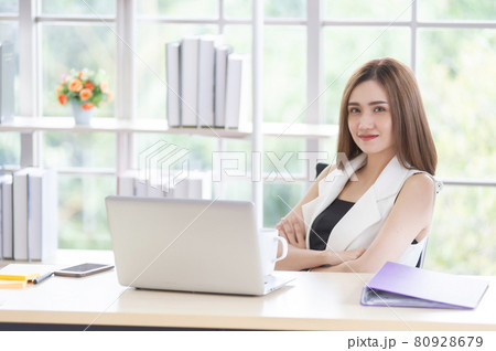 Smiling Asian businesswoman working on a laptop in the office, felling enjoy and looking at the camera, happy working in the workplace Smiling Asian businesswoman working on a laptop in the office, felling enjoy and looking at the camera, happy working in the workplace 80928679