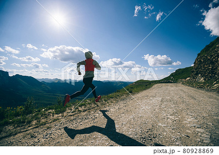 Young woman ultramarathon runner running at mountain top 80928869