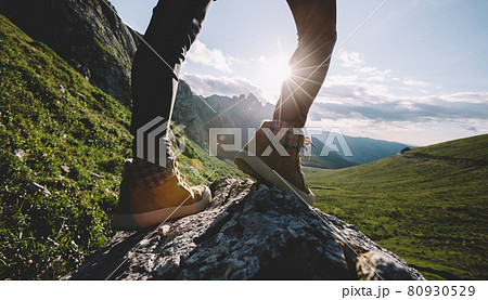 Successful woman backpacker hiking on sunset alpine mountain peak Successful woman backpacker hiking on sunset alpine mountain peak 80930529