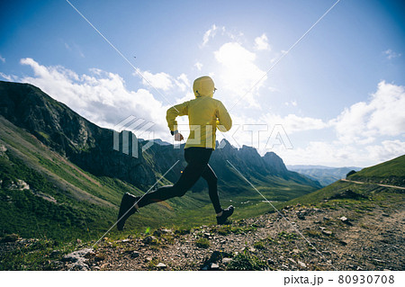 Woman ultramarathon runner running at mountain top 80930708