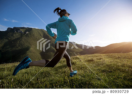 Young woman ultramarathon runner running at mountain top 80930729