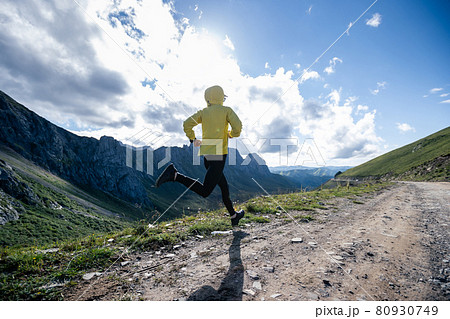 Young woman ultramarathon runner running at mountain top 80930749