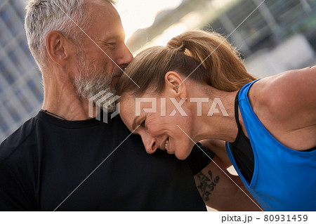 Portrait of affectionate middle aged couple, man and woman in sportswear having morning workout in the city on a summer day 80931459