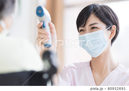介護イメージ 非接触体温計で検温する医療従事者 介護イメージ 非接触体温計で検温する医療従事者 80932691
