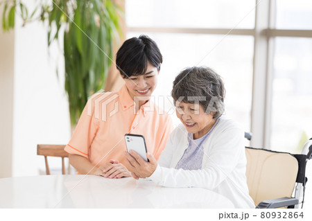 介護イメージ スマホを見るシニア女性と介護士のポートレート 介護イメージ スマホを見るシニア女性と介護士のポートレート 80932864