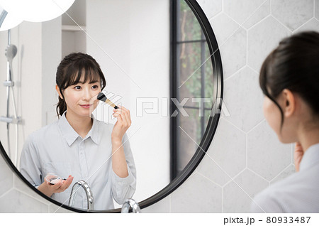 バスルームの鏡の前でお化粧をする女性 バスルームの鏡の前でお化粧をする女性 80933487