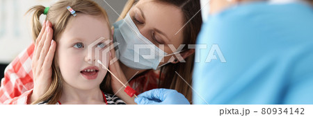 Doctor taking pcr swab from nose of little girl using cotton swab at clinic 80934142