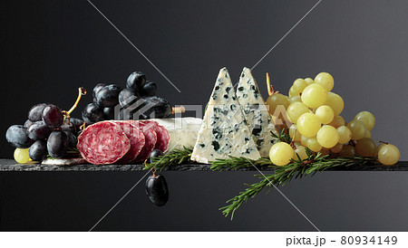 Blue cheese, dry-cured sausage, grapes, and rosemary. 80934149