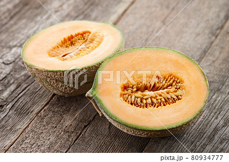 Halves of cantaloupe melon on old wooden planks 80934777