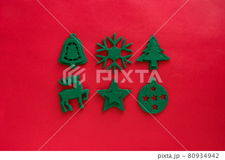 Kraft felt green toys composition. Christmas decorations on red surface. Felt decor - deer, snowflake, bauble, tree, star. Top view, flat lay Kraft felt green toys composition. Christmas decorations on red surface. Felt decor - deer, snowflake, bauble, tree, star. Top view, flat lay 80934942