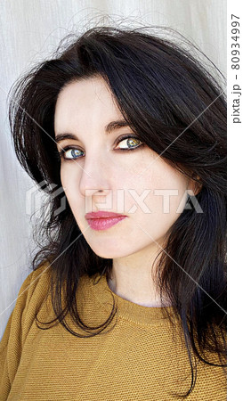 A young woman in a golden colored jumper A young woman in a golden colored jumper 80934997