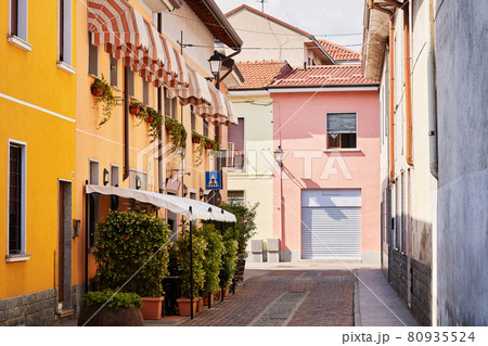 Outdoor restaurant terrace on narrow cosy italian street, cafe in small town in Lombardy, Italy. Trattoria exterior 80935524