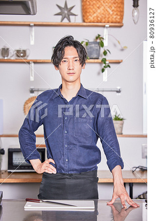 エプロンをつけてキッチンに立つ若い男性 料理男子イメージ エプロンをつけてキッチンに立つ若い男性 料理男子イメージ 80936127