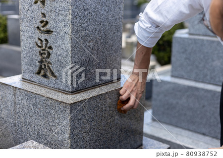 お墓参りに来てたわしでお墓の掃除をしている男性 お墓参りに来てたわしでお墓の掃除をしている男性 80938752