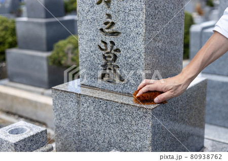 お墓参りに来てたわしでお墓の掃除をしている男性 80938762