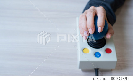 Woman with cerebral palsy works on a specialized computer mouse. Woman with cerebral palsy works on a specialized computer mouse. 80939392