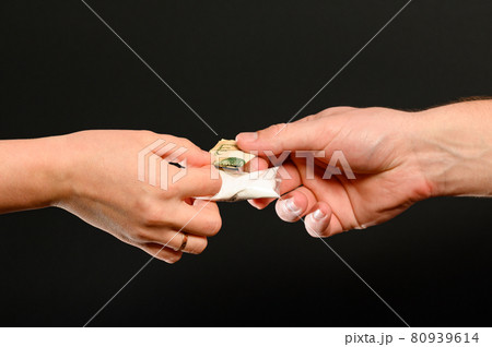 The drug dealer passes the white powder to the customer, the illicit distribution of the drug. The drug dealer passes the white powder to the customer, the illicit distribution of the drug. 80939614