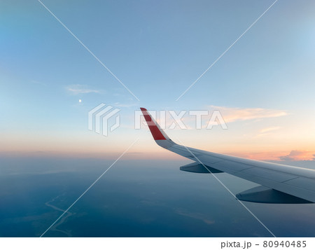 The plane flies and turns aligns at sunset The plane flies and turns aligns at sunset 80940485