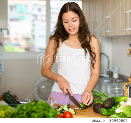 Portrait of woman making fresh vegetable salad 80940605