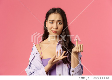 Women, relationship and people concept. Close-up portrait of gloomy complaining asian girl showing finger without ring, smirk and frowning upset, want get married, why boyfriend dont make proposal Women, relationship and people concept. Close-up portrait of gloomy complaining asian girl showing finger without ring, smirk and frowning upset, want get married, why boyfriend dont make proposal 80941118
