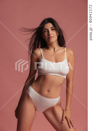 Close-up portrait of young beautiful arabian woman without makeup isolated over pink studio background. Natural beauty concept. Close-up portrait of young beautiful arabian woman without makeup isolated over pink studio background. Natural beauty concept. 80941572