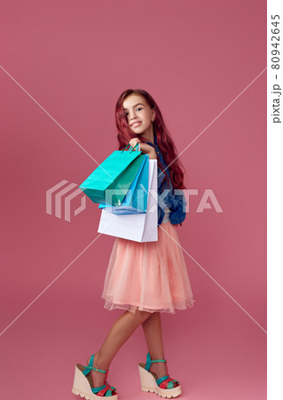 little caucasian child girl holds shopping bags 80942645
