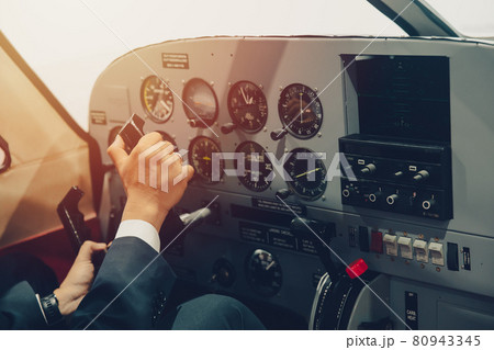 Pilot hand or private flight captain control airplane with many aircraft gauge in cockpit dashboard. Pilot hand or private flight captain control airplane with many aircraft gauge in cockpit dashboard. 80943345