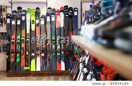 Variety of alpine skis for sale in modern sports equipment store 80944184