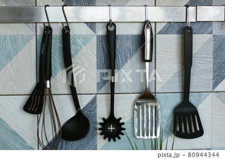 kitchen close up fragment with spatulas , mixer utensils on blue tile background 80944344