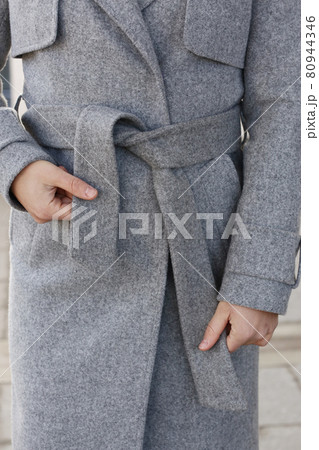 gray woolen coat closeup detail with model hands on city street background gray woolen coat closeup detail with model hands on city street background 80944346
