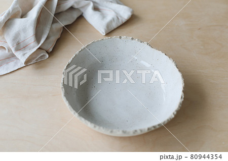 Ceramic bowl on a wooden table top view. Handmade ceramic tableware and pottery 80944354