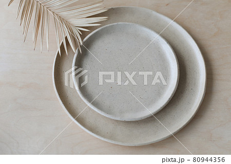 Ceramic plate on a wooden table top view. minimalist handmade ceramic tableware and pottery 80944356