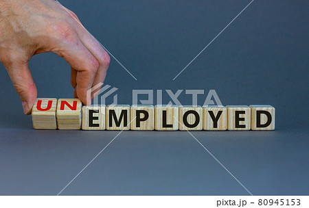 Hand turns a cube and changes the word 'unemployed' to 'employed'. Beautiful grey background, copy space. Business concept. Hand turns a cube and changes the word 'unemployed' to 'employed'. Beautiful grey background, copy space. Business concept. 80945153