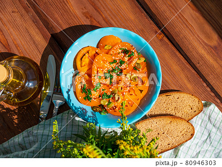 Yellow tomatoes salad with rye bread slices in blue ceramic bowl top view. Ripe fresh colorful vegetables mixed greens 80946303