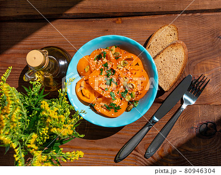Yellow tomatoes salad with rye bread slices in blue ceramic bowl top view. Ripe fresh colorful vegetables mixed greens 80946304