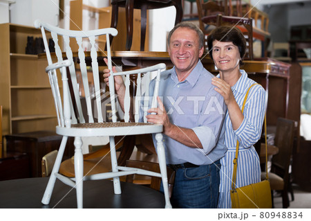 Cheerful couple is shopping the old armchair Cheerful couple is shopping the old armchair 80948834