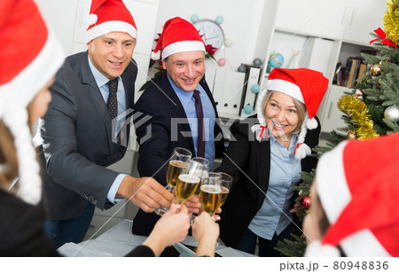 Colleagues celebrating Christmas in office Colleagues celebrating Christmas in office 80948836