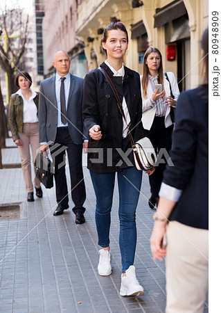 People in formal wear walking down street in city People in formal wear walking down street in city 80948909