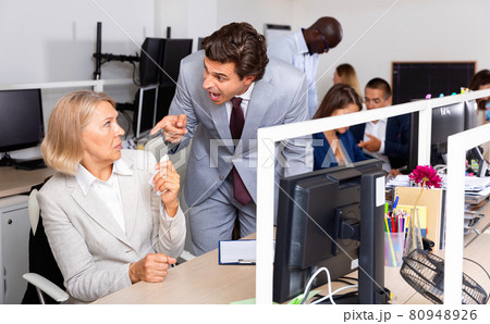 Annoyed boss scolding mature female subordinate pointing out shortcomings and misses in work Annoyed boss scolding mature female subordinate pointing out shortcomings and misses in work 80948926